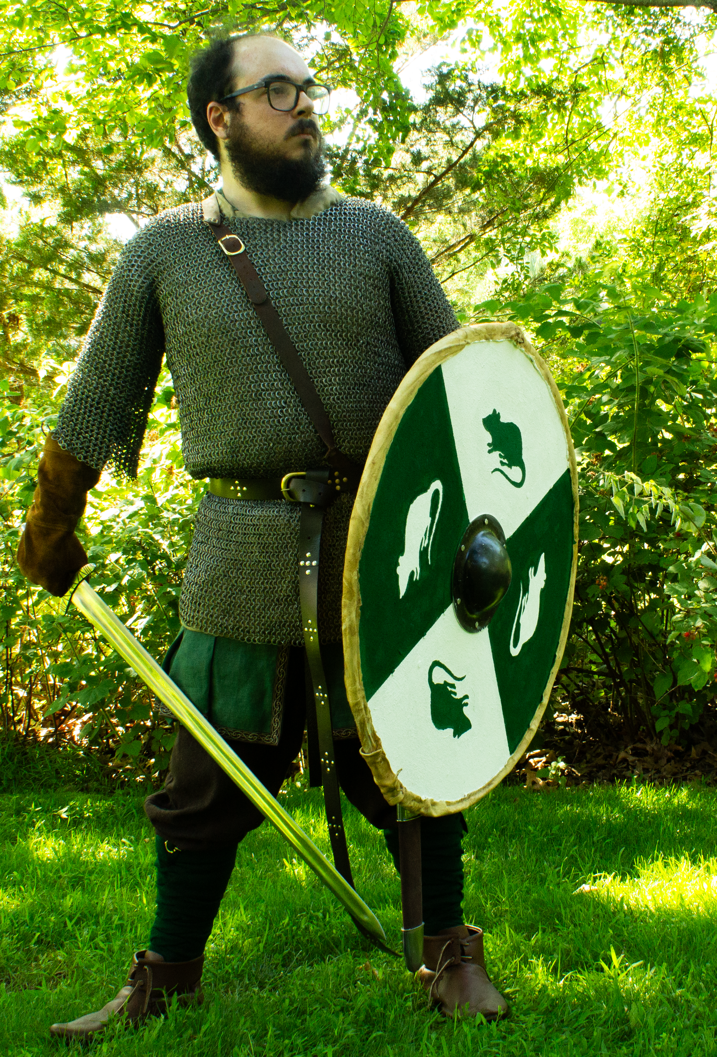 A Viking warrior with the aforementioned green and white shield, as well as a sword, standing tall and ready